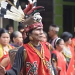 Vibrant celebration of Dayak culture with traditional costumes and rituals in Kalimantan Barat, Indonesia.